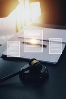 Justice and law concept.Male judge in a courtroom with the gavel, working with, computer and docking keyboard, eyeglasses, on table in morning light photo