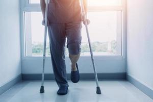 young asian physical therapist working with senior woman on walking with a walker photo