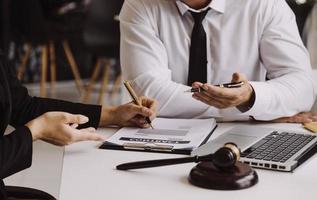 Male lawyer working with contract papers and wooden gavel on tabel in courtroom. justice and law ,attorney, court judge, concept. photo