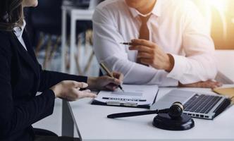 Male lawyer working with contract papers and wooden gavel on tabel in courtroom. justice and law ,attorney, court judge, concept. photo