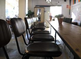 Row of leather seats next to a wooden table photo