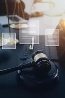 Justice and law concept.Male judge in a courtroom with the gavel, working with, computer and docking keyboard, eyeglasses, on table in morning light photo