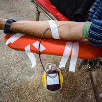 Blood donor at Blood donation camp held with a bouncy ball holding in hand at Balaji Temple, Vivek Vihar, Delhi, India, Image for World blood donor day on June 14 every year, Blood Donation Camp photo