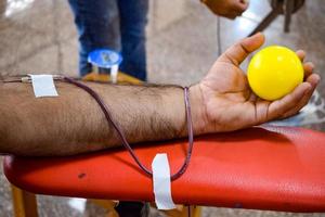 donante de sangre en el campamento de donación de sangre sostenido con una pelota hinchable en la mano en el templo balaji, vivek vihar, delhi, india, imagen para el día mundial del donante de sangre el 14 de junio de cada año, campamento de donación de sangre foto