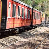 Toy Train moving on mountain slopes, beautiful view, one side mountain, one side valley moving on railway to the hill, among green natural forest. Toy train from Kalka to Shimla in India, Indian Train photo