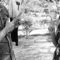 Indian couple posing for maternity baby shoot. The couple is posing in a lawn with green grass and the woman is falunting her baby bump in Lodhi Garden in New Delhi, India - Black and White photo