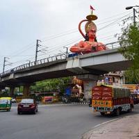 New Delhi, India - June 21, 2022 - Big statue of Lord Hanuman near the delhi metro bridge situated near Karol Bagh, Delhi, India, Lord Hanuman statue touching sky photo