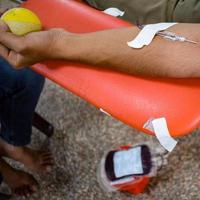 Blood donor at Blood donation camp held with a bouncy ball holding in hand at Balaji Temple, Vivek Vihar, Delhi, India, Image for World blood donor day on June 14 every year, Blood Donation Camp photo