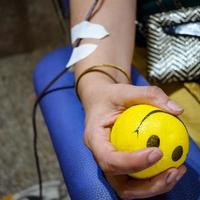 donante de sangre en el campamento de donación de sangre sostenido con una pelota hinchable en la mano en el templo balaji, vivek vihar, delhi, india, imagen para el día mundial del donante de sangre el 14 de junio de cada año, campamento de donación de sangre foto