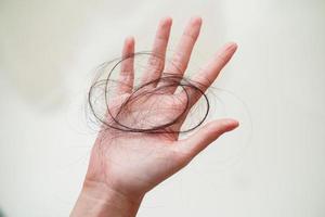 Asian woman have problem with long hair loss attach in her hand. photo