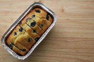 pastel de muffin de arándanos en un molde para pan sobre una mesa de madera foto