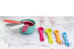 Set of measuring cups, measuring spoons and measuring glasses use in cooking lay on marble tabletop in eye level view photo