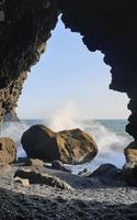 olas que llegan a reynisfjara black beach, islandia, con formaciones rocosas en el fondo foto