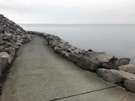 un camino vacío que conduce alrededor de una curva en la costa de Keflavik, Islandia foto