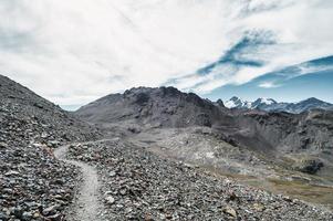 Trail through stony terrain in the Swiss mountains photo