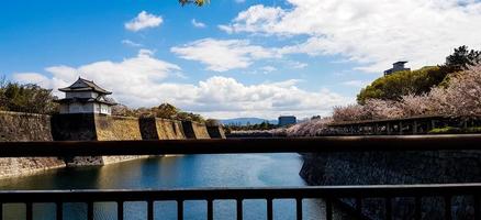 The surroundings of Osaka Castle in spring season with beautiful sky, calm river and cherry blossom. photo