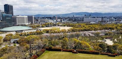 View from the roof of Osaka Castle as seen from the roof with scenery of Osaka skyscrapers in Osaka City and the park around the Castle photo