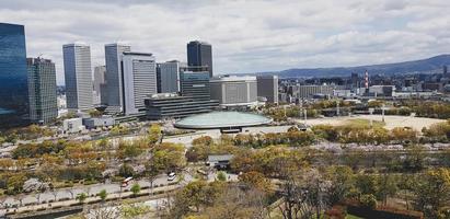 View from the roof of Osaka Castle as seen from the roof with scenery of Osaka skyscrapers in Osaka City and the park around the Castle photo