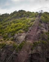 Aeria view ropeway empty bucket above road in Mining area in Chiatura. Transporting container. Sunset over industry cranes and cable railway. Transportation and mining Industry photo