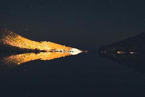 perosn on rock in mountains at night head torch photo