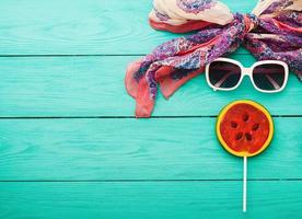 Summer accessories with candy on blue wooden background. Top view and selective focus photo