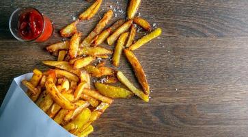 Menú de comida rápida de patatas fritas o patatas fritas caseras sobre fondo de madera.vista superior foto