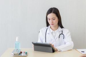 Asian female doctors use tablets to consult information. photo