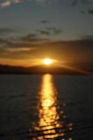 desenfocado en un colorido cielo dramático con nubes al atardecer. puesta de sol en el lago foto