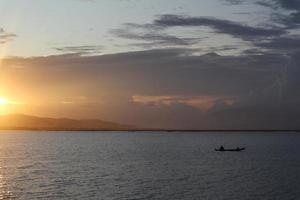 silueta de pescador en su barco foto