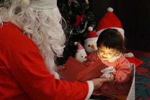 Little girl childhood cute happy smiling delighted with a gift box from Uncle Santa Claus. festival celebration. Merry Christmas happy new year concept photo