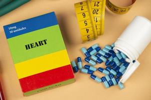 Fake medicine box with the name of the disease Heart and a glucometer. photo