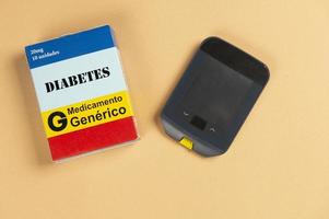 caja de medicamentos falsos con el nombre de la enfermedad diabetes y un glucómetro. foto