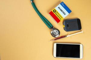 Fake medicine box with the name of the disease Diabetes and a glucometer. photo