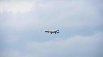 avión de carga de fuselaje ancho acercándose, con ráfaga de nubes y condensación, antes de aterrizar en el aeropuerto de Singapur video