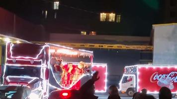 Tbilisi, Georgia, 2021- traditional red coca cola xmas open roof festive truck with white teddy bears inside. Christmas holiday celebrations and festive vehicle on road video