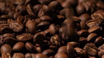 Slow motion of roasted coffee beans falling. Organic coffee seeds.