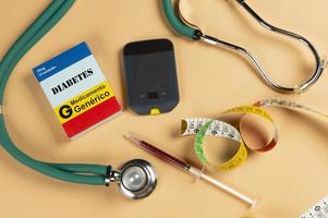 Fake medicine box with the name of the disease Diabetes and a glucometer. photo