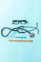 Text phrase Coronavirus syringe eyeglasses and stethoscope on blue pastel background. Novel coronavirus 2019-nCoV MERS-Cov covid-19 middle East respiratory syndrome coronavirus virus vaccine concept. photo