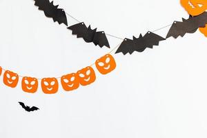 Trick or Treat concept. Holiday composition with halloween garland decorations pumpkins and bats isolated on white background. Preparation for Halloween party. Autumn fall happy Halloween photo