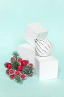 Simply minimal composition winter objects ornament and cube shapes geometric form podium isolated blue pastel background. Christmas New Year december time for celebration concept. Mockup, copy space photo