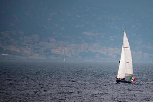 sailboat on deep blue sea on foggy day photo