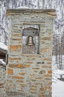 campanario de la iglesia de piedra de la montaña en invierno foto