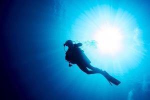 diver silhouette in the blue sea photo