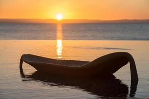 sun chair by the sea at sunset photo