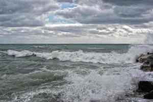 sea in tempest on rocks of italian village photo