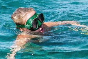 beauty blonde diver girl looking at you while snorkeling photo