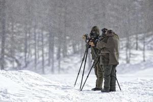 fotógrafos bajo la tormenta de nieve en muntain foto