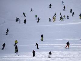 many skiers skiing in dolomites gardena valley snow mountains photo
