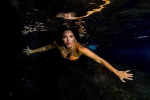 sirena nadando bajo el agua en el mar azul profundo foto