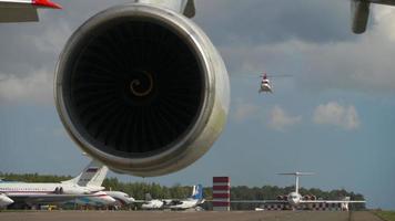 kazan, fédération de russie, 14 septembre 2020 - vue sur le tablier de l'aéroport de kazan derrière la nacelle moteur d'antonov an 124 avions de transport. hélicoptère descendant en arrière-plan. video